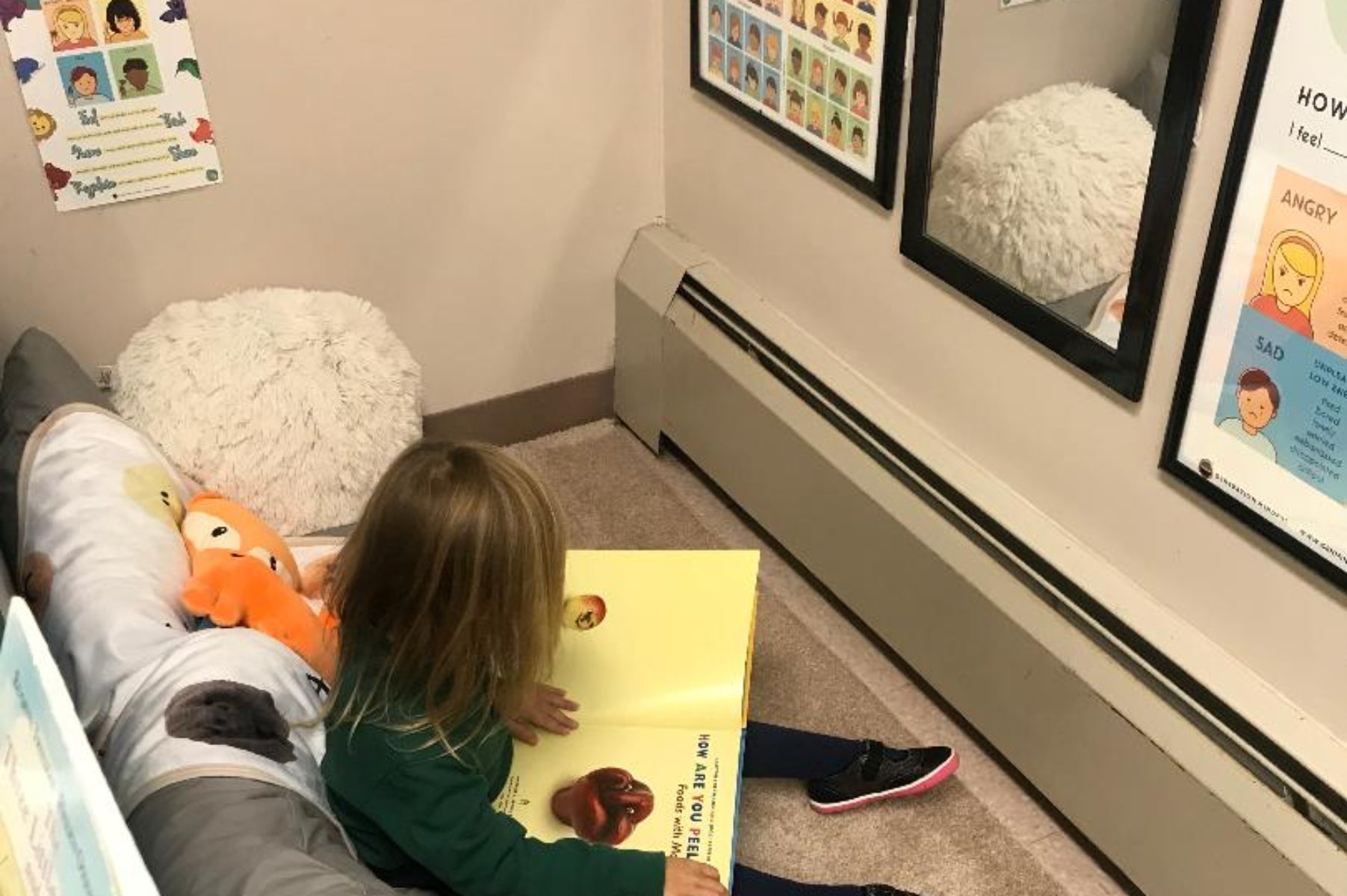 Child reading a book in classroom's Calming Corner