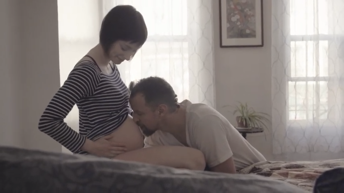A man kissing his pregnant wife's belly
